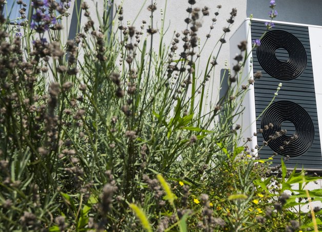 Bild zeigt eine Wärmepumpe im Garten – wie laut Wärmepumpen sind, ist ein wichtiger Faktor bei der Installation.